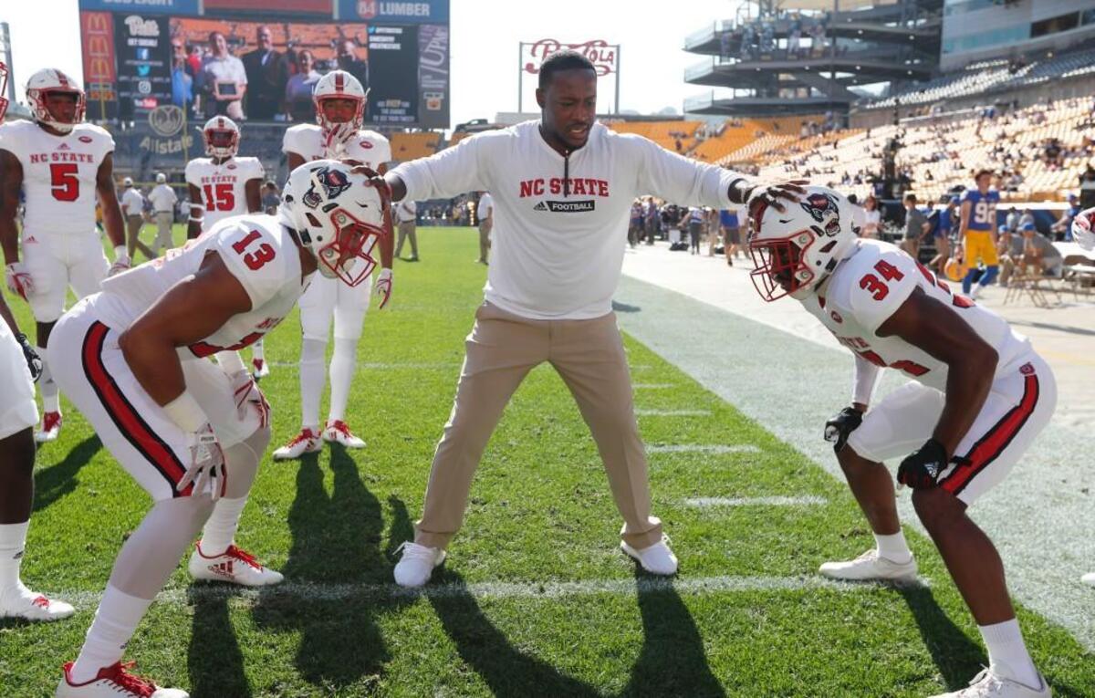 N.C. State safeties coach Aaron Henry works with Stephen Morrison (13) and Tim Kidd-Glass (34) before the Wolfpack's game against Pittsburgh at Heinz Field in Pittsburgh on Oct .14, 2017.