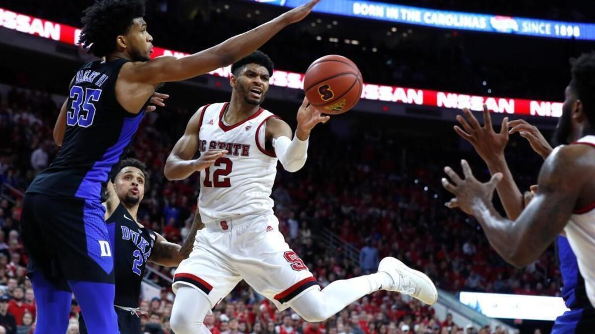 Allerik Freeman, middle, passes the ball to Lennard Freeman during the Wolfpack’s 96-85 win over Duke on Saturday.