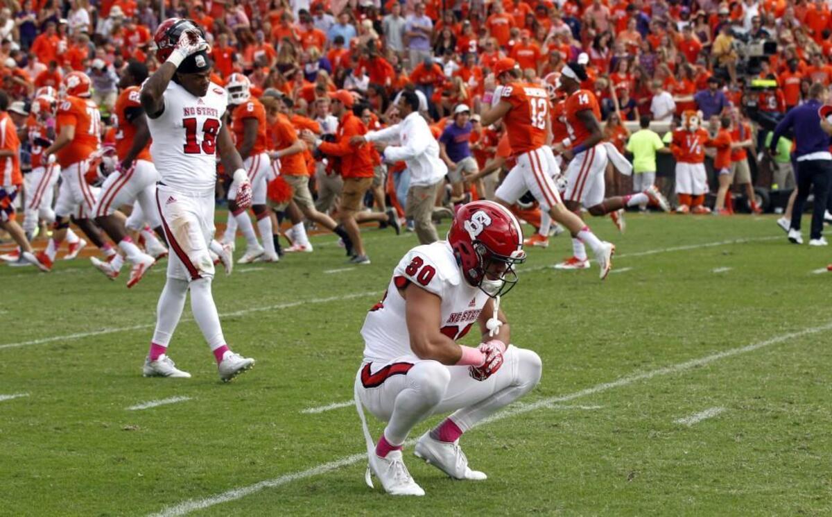 N.C. State's Bra'Lon Cherry (13), left, and Gavin Locklear (30) react after Clemson's 24-17 overtime victory at Memorial Stadium on Oct. 15, 2016.