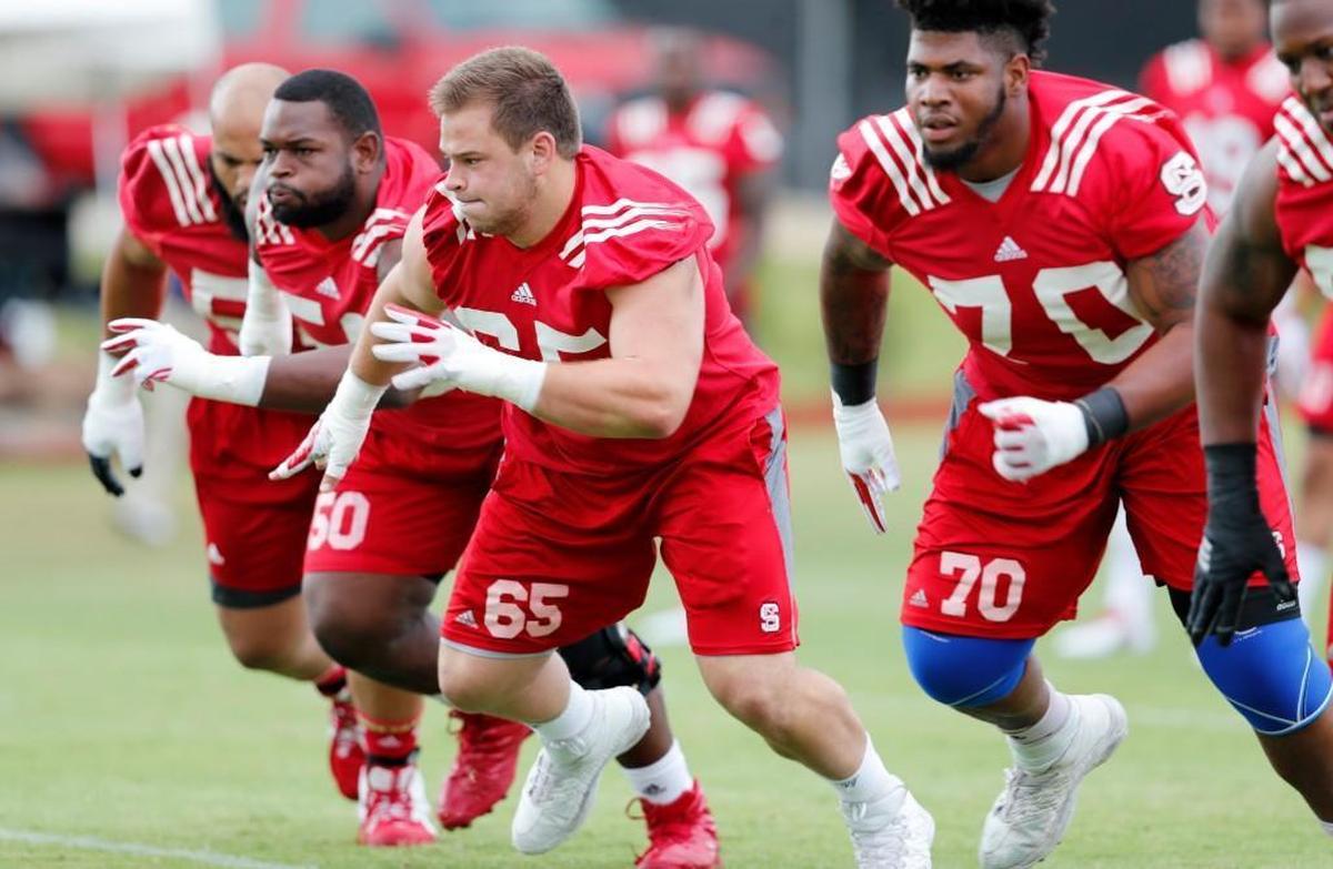 From left, N.C. State’s Will Richardson (54), Tony Adams (50), Garrett Bradbury (65) and Terronne Prescod (70) run a drill during the Wolfpack’s first practice in July 29.
