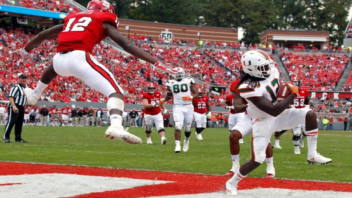 Miami's Malek Young intercepts the ball intended for N.C. State wide receiver Stephen Louis (12) in the end zone during the second half at Carter-Finley Stadium.