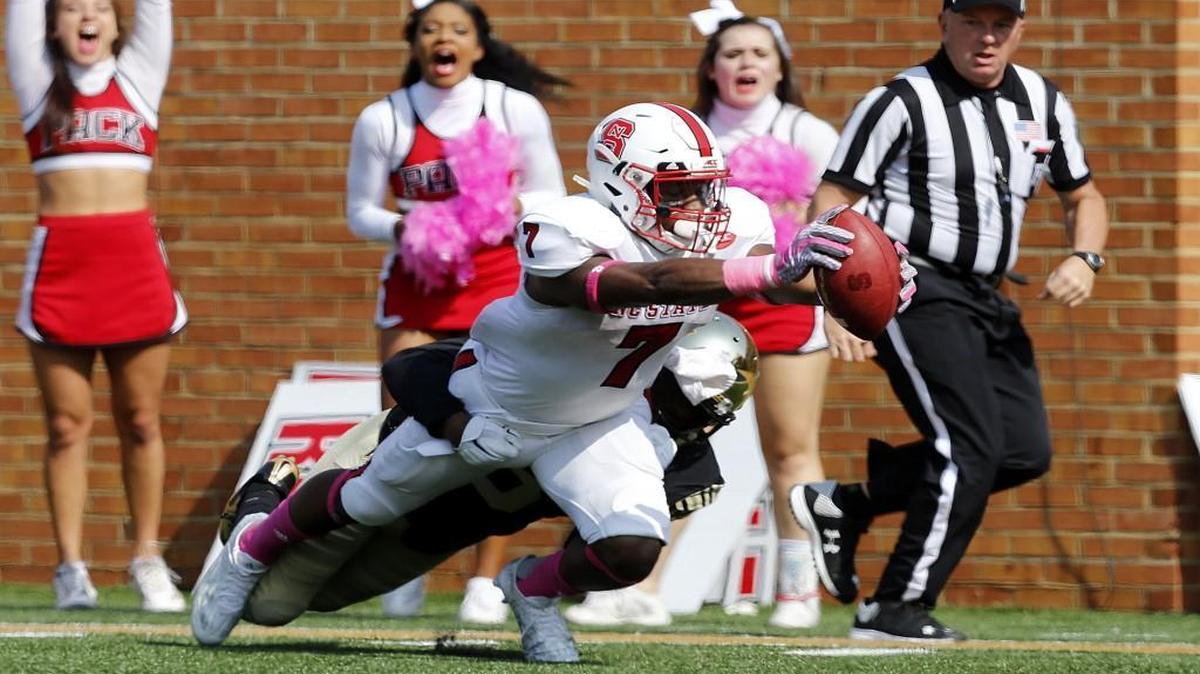 N.C. State's Nyheim Hines dives in to score on a 58-yard touchdown reception as Wake Forest's Devin Gaulden (3) defends during the first half at BB&T Field in Winston-Salem.