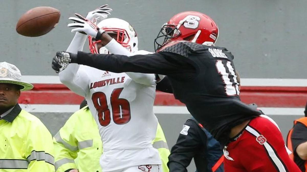 
N.C. State cornerback Juston Burris (11) breaks up a pass intended for Louisville wide receiver Devonte Peete (86) during the first half of the Wolfpack's game against Louisville at Carter-Finley Stadium in Raleigh, N.C., Saturday, Oct. 3, 2015.
