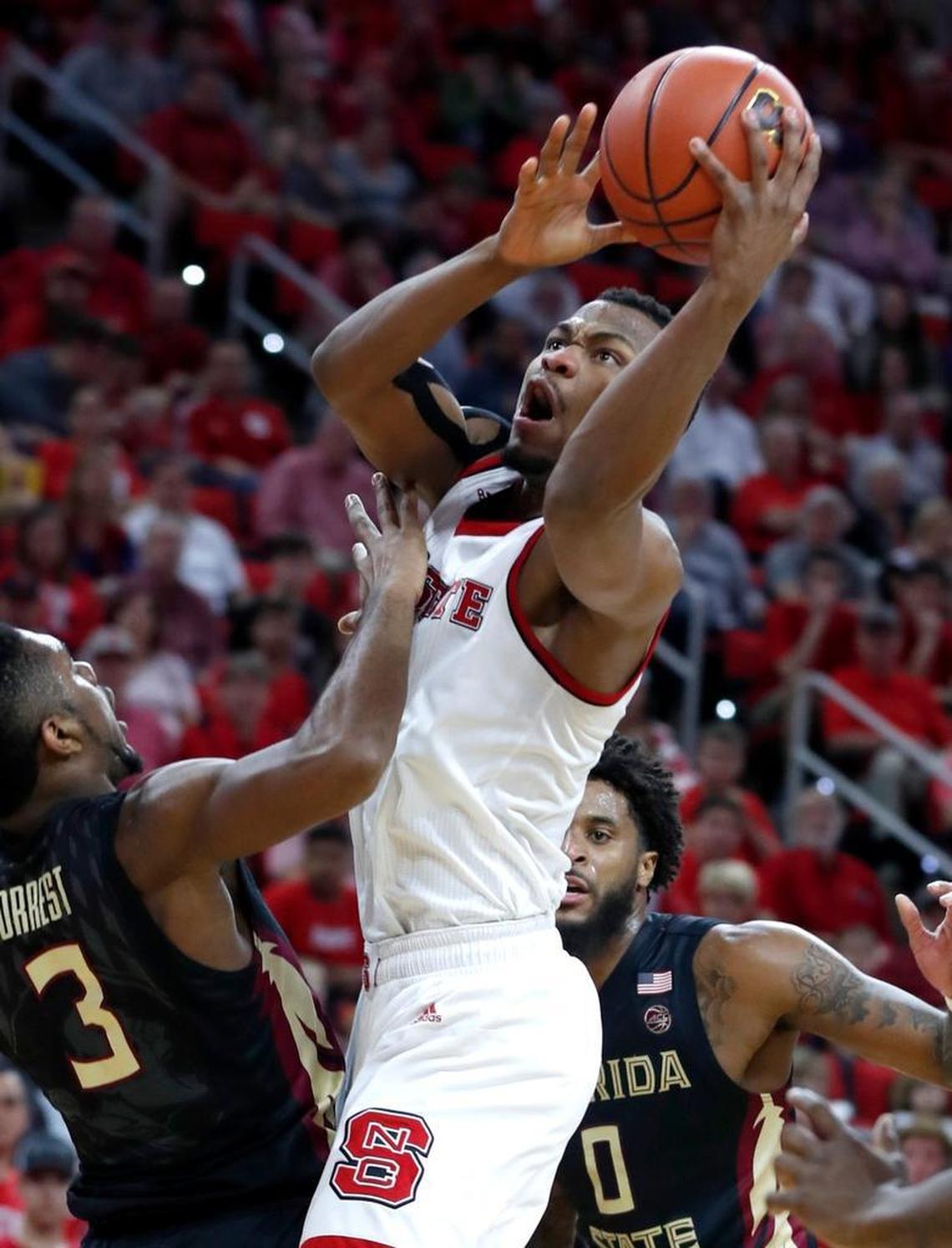 N.C. State's Torin Dorn (2) shoots as Florida State's Trent Forrest (3) defends during the first half of N.C. State's game against Florida State at PNC Arena on Feb. 25, 2018.