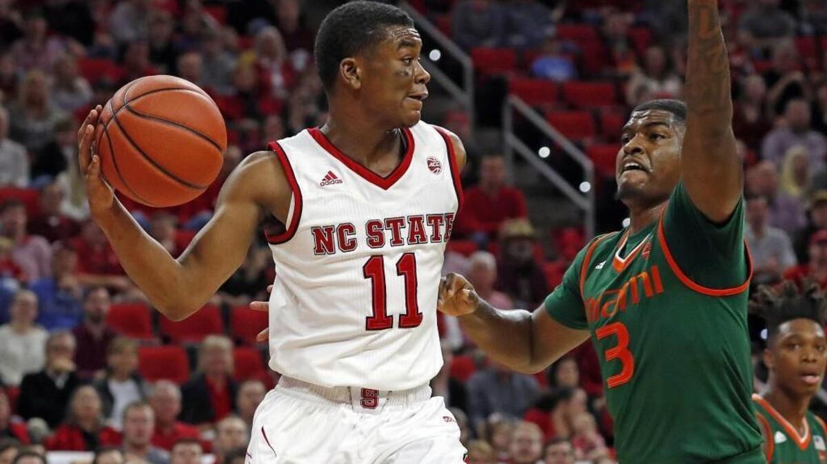 North Carolina State's Markell Johnson (11) looks to pass the ball around Miami's Anthony Lawrence II (3) during the first half of an NCAA college basketball game in Raleigh, N.C., Sunday, Jan. 21, 2018. (AP Photo/Karl B DeBlaker)