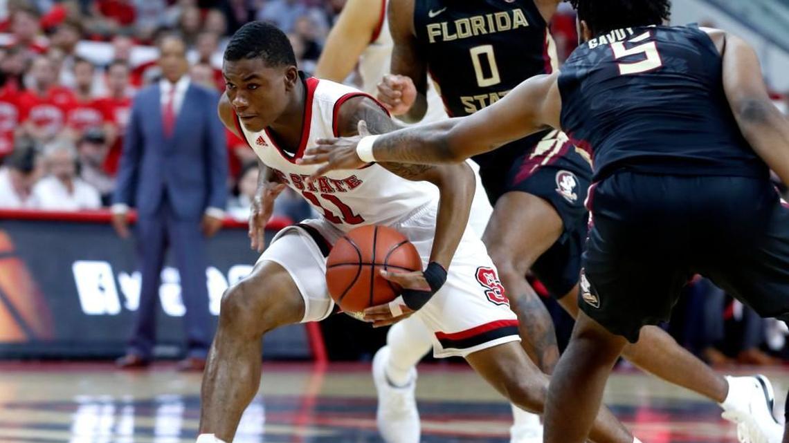 N.C. State's Markell Johnson (11) drives by Florida State's PJ Savoy (5) during the first half of N.C. State's game against Florida State at PNC Arena in Raleigh, N.C., Sunday, Feb. 25, 2018.