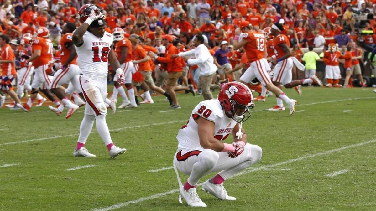 N.C. State's Bra'Lon Cherry (13), left, and Gavin Locklear (30) react after Clemson's 24-17 overtime victory at Memorial Stadium in Clemson.