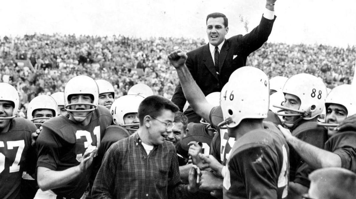 Coach Ara Parseghian salutes the Dyche stadium crowd with the game ball as his Northwestern Wildcats carry him off the field following their 21-0 victory over Ohio State on Nov. 1, 1958.