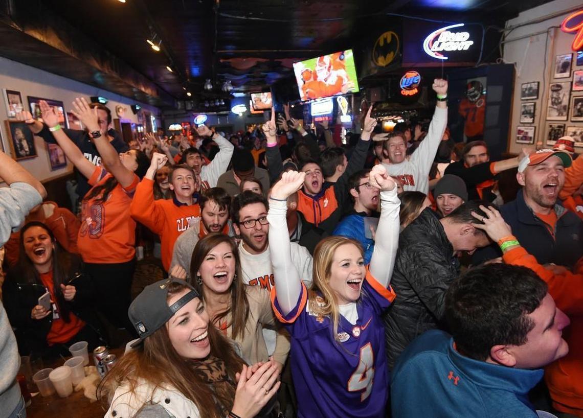 Clemson fans watch the college football championship in January. Football conference television deals have helped drive up coaching salaries over the past 10 years.