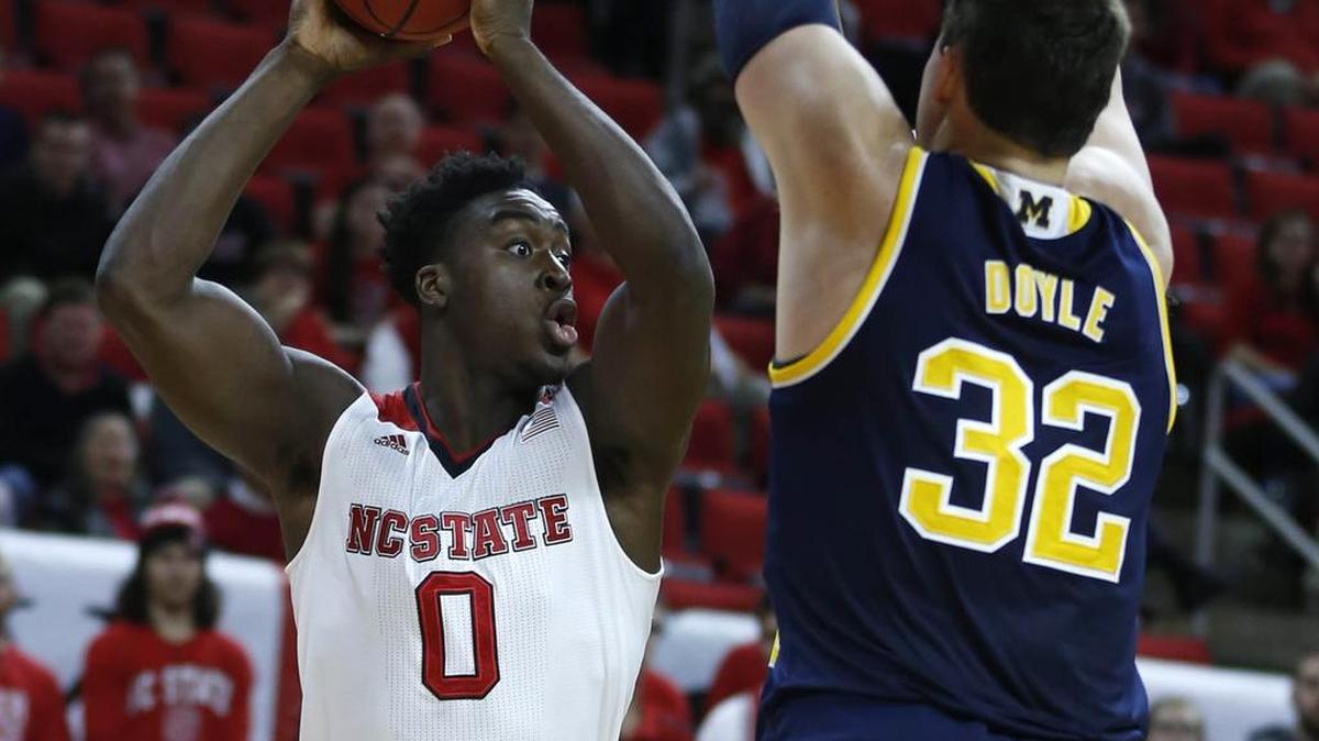 N.C. State's Abdul-Malik Abu (0) tries to pass out of the pressure by Michigan's Ricky Doyle (32) during the first half of the Wolfpack's game against Michigan at PNC Arena in December.