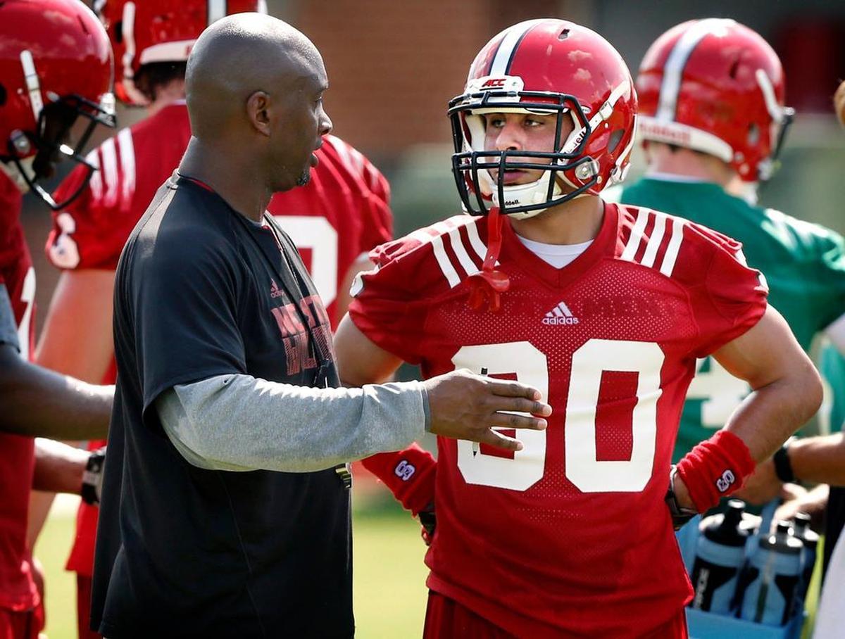 N.C. State wide receivers coach George McDonald talks with Gavin Locklear (30) during the Wolfpack's first preseason practice on Aug. 4, 2015.