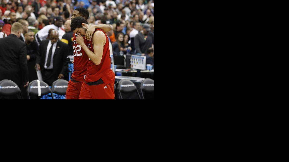 
N.C. State's Ralston Turner (22) and Caleb Martin walk off the court after Louisville's 75-65 victory over the Wolfpack in the semifinals of the NCAA East Region at the Carrier Dome in Syracuse,.
