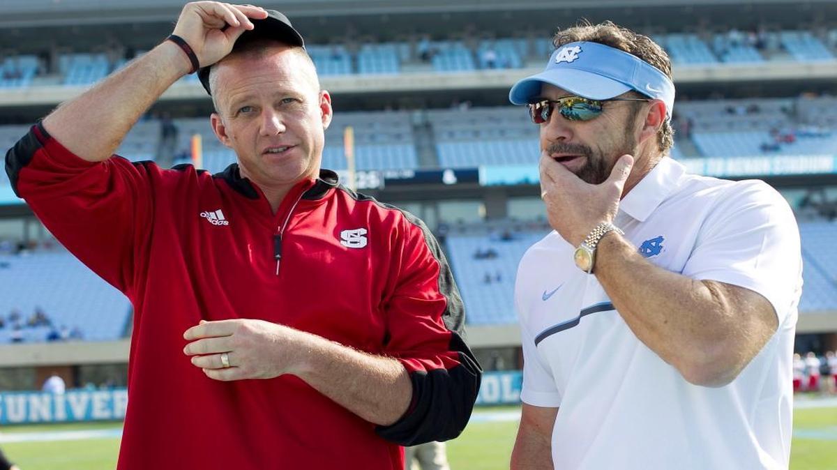North Carolina coach Larry Fedora talks with N.C. State coach Dave Doeren prior to the kick off of their game at Kenan Stadium in Chapel Hill.