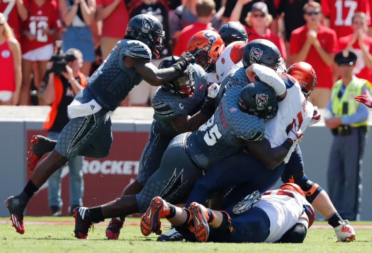On fourth and one with 7:47 left in the second quarter, N.C. State’s Kentavius Street (35) and the defense stop Syracuse quarterback Eric Dungey (2) for no gain during the Wolfpack’s victory at Carter-Finley Stadium in Raleigh Saturday, Sept. 30, 2017.