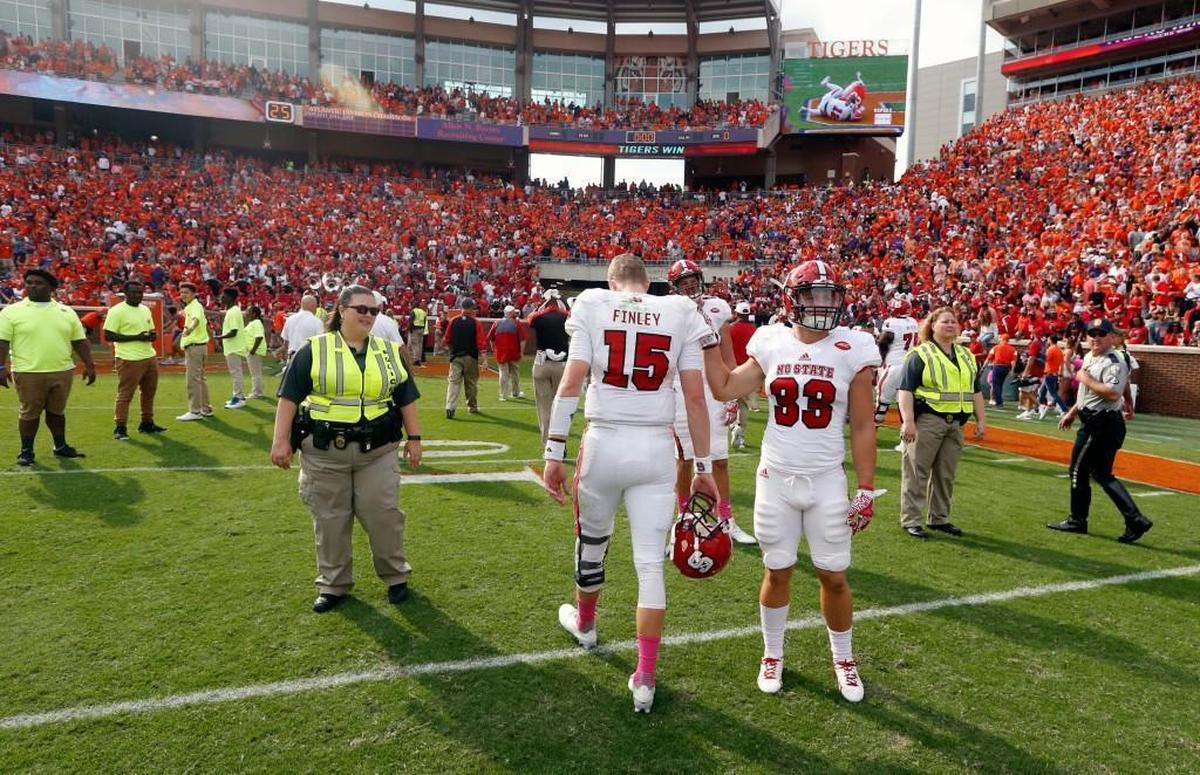 N.C. State quarterback Ryan Finley (15) walks off the field after Clemson’s 24-17 overtime victory at Memorial Stadium in Clemson. State’s Brady Bodine (33) is to the right.