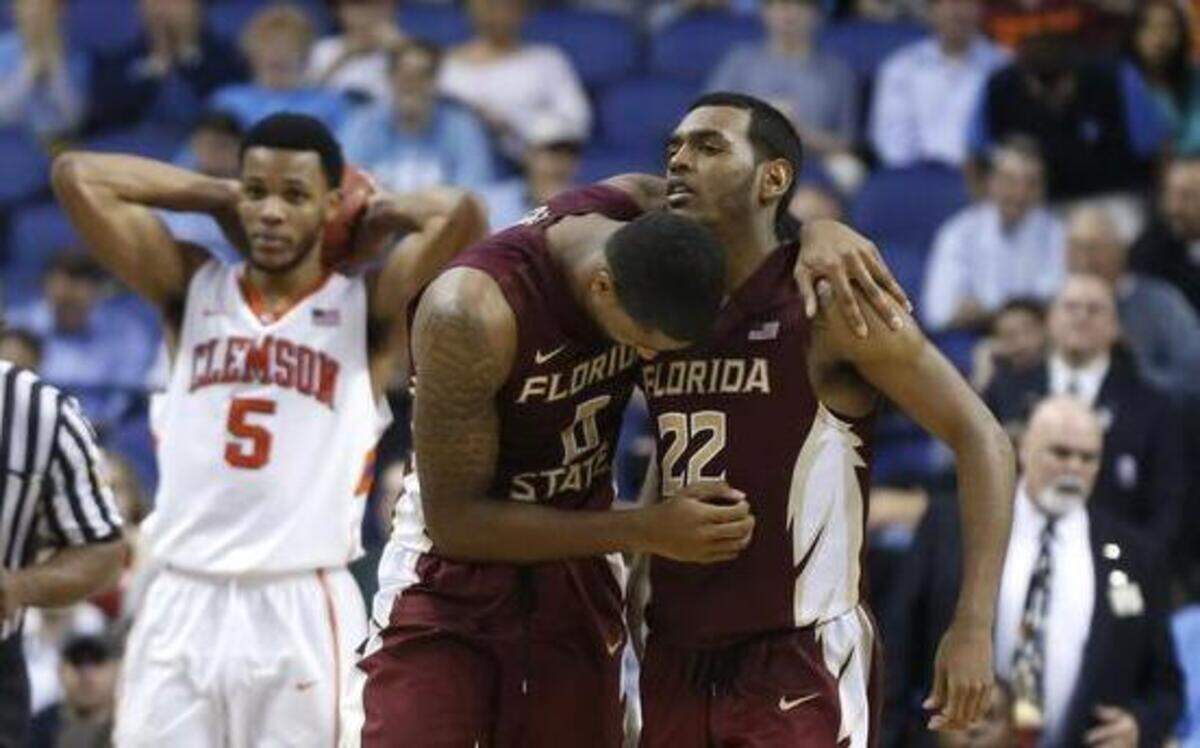 
Clemson’s Jaron Blossomgame (left) shows his disappointment as Florida State's Phil Cofer and Xavier Rathan-Mayes celebrate after the Seminoles’ 76-73 victory against the Tigers in the second round of the ACC men’s basketball tournament in Greensboro. 
