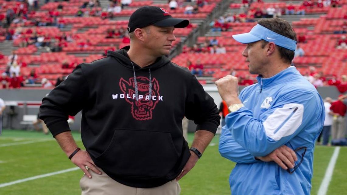 N.C. State coach Dave Doeren, left, and North Carolina coach Larry Fedora chat prior to their 2015 game at Carter Finley Stadium. The prospect of divisional realignment did not come up when ACC coaches met this week.