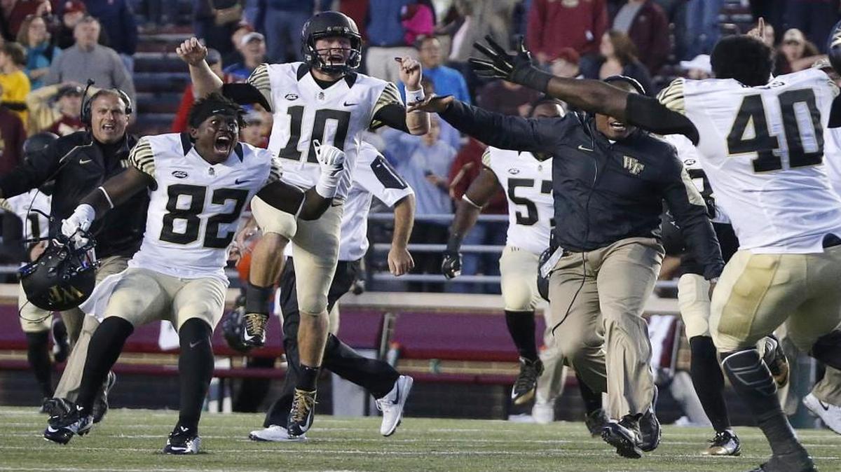 
Wake Forest wide receiver P.J. Howard IV (82) and quarterback John Wolford (10) celebrate with teammates after time ran out on Boston College in the fourth quarter to preserver the Deacons 3-0 win. 
