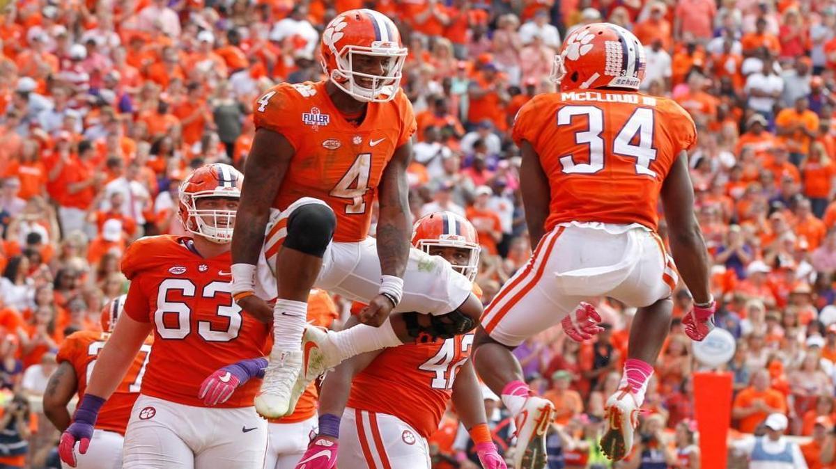 Clemson quarterback Deshaun Watson (4) celebrates with Ray-Ray McCloud (34) after scoring on four-yard touchdown run during Tiger's 24-17 overtime victory over N.C. State at Memorial Stadium in Clemson.