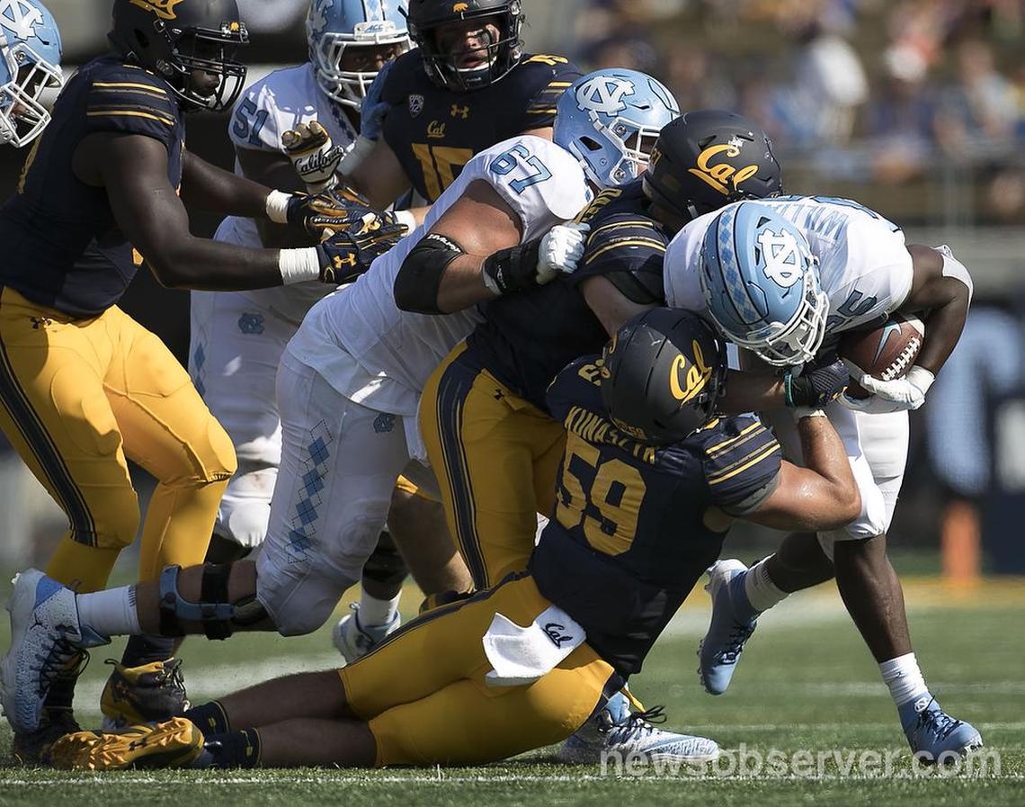 North Carolina’s Javonte Williams (25) is stopped by California’s Jordan Kunaszyk (59) in the fourth quarter on Saturday, Sept. 1, 2018, at Memorial Stadium in Berkeley, Ca.