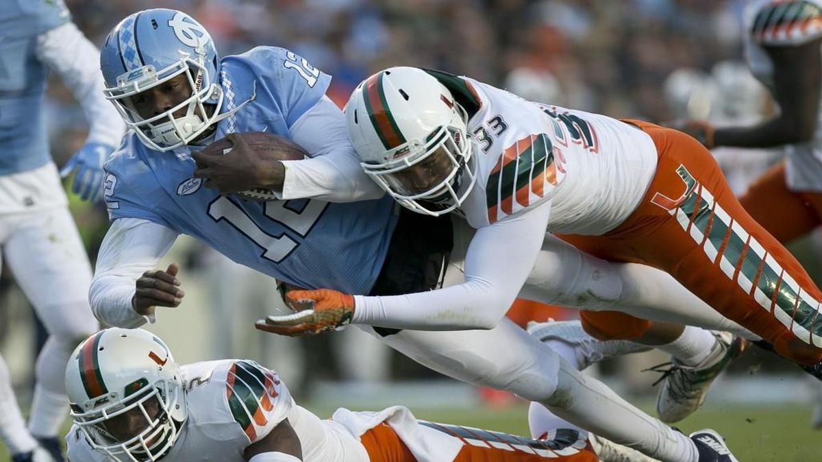 North Carolina quarterback Marquise Williams scores a touchdown on a 14-yard run against Miami’s Trent Harris (33) to give the Tar Heels a 24-0 lead in the second quarter at Kenan Stadium in Chapel Hill.