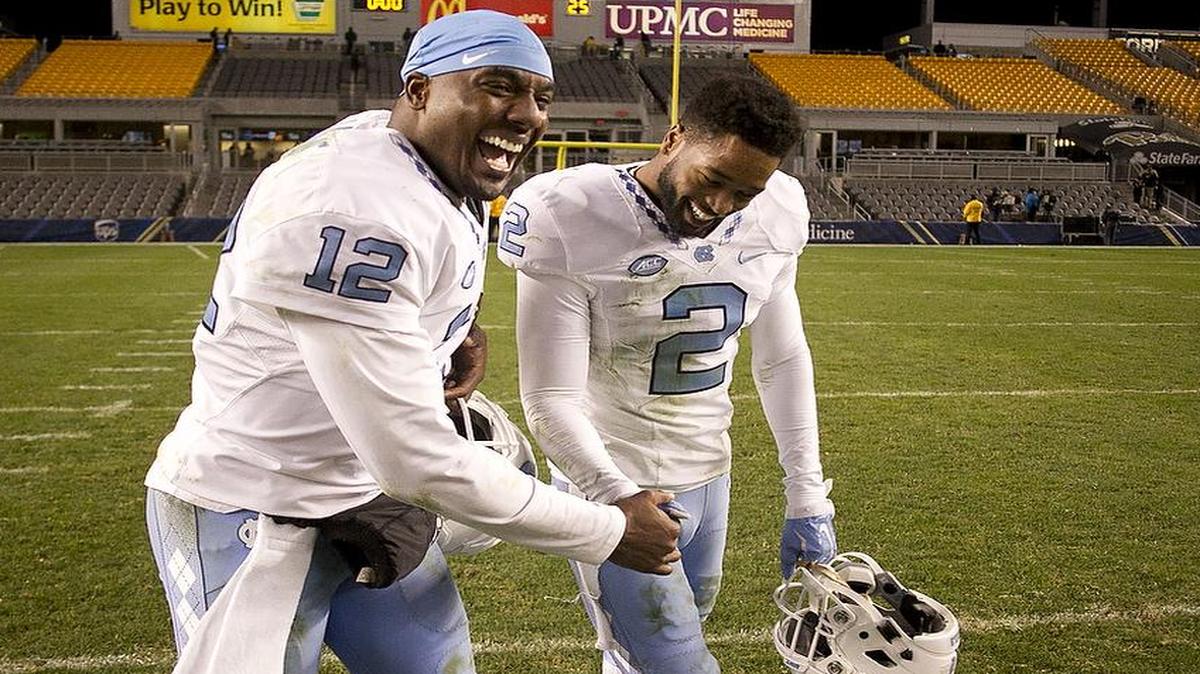 North Carolina quarterback Marquise Williams (12) and Des Lawrence (2) celebrates the Tar Heels’ 26-19 victory over Pittsburgh in an empty stadium.