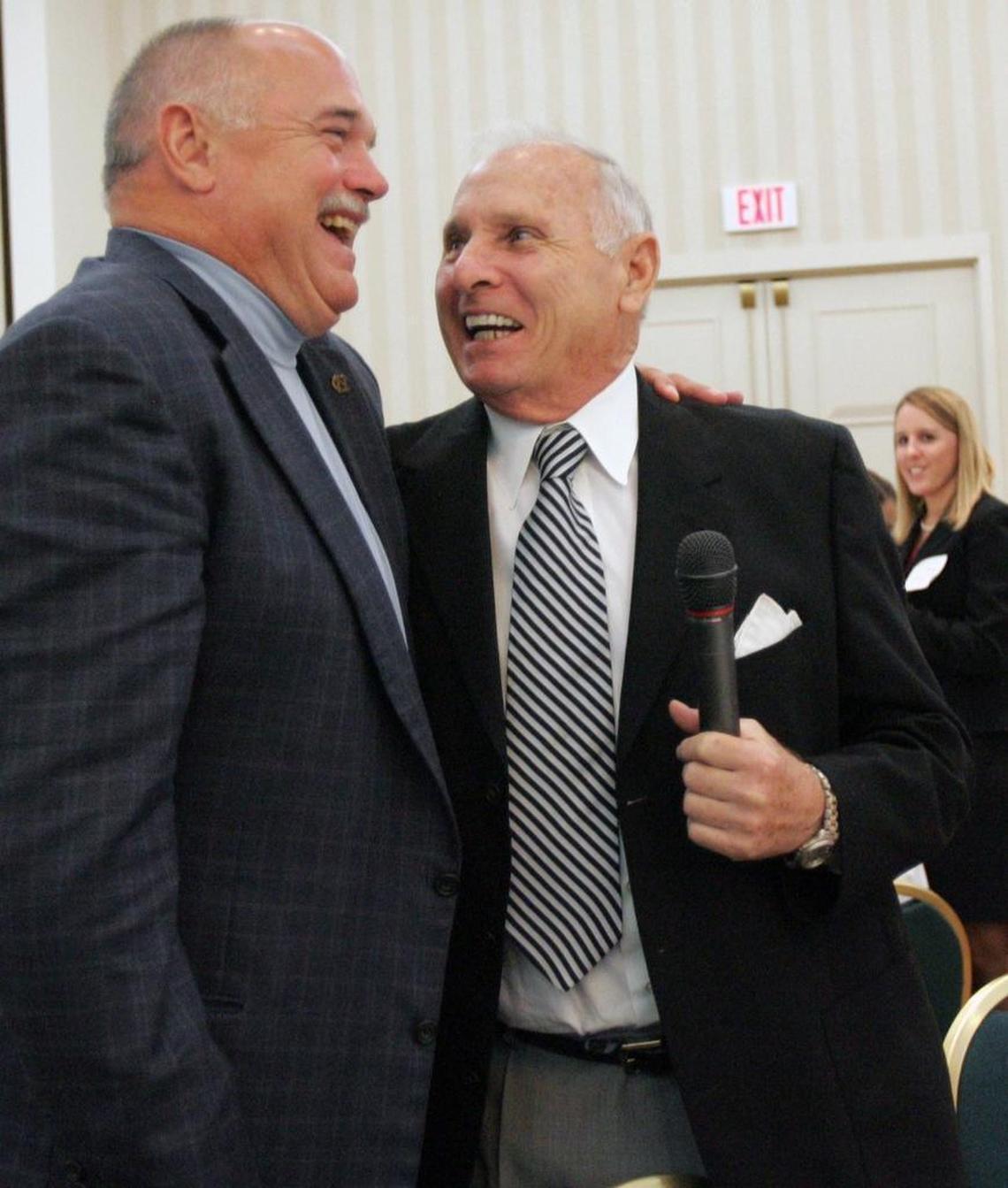 UNC head football coach John Bunting, left, gives former North Carolina head football coach Bill Dooley a hug before Dooley spoke to the crowd during the 4th Annual National Football Foundation and College Hall of Fame Triangle Pigskin Preview in 2006. Bunting played football for Dooley, who coached 11 seasons at North Carolina. Dooley also was the head coach at Wake Forest. Dooley died Tuesday, August 9, 2016 at age 82.