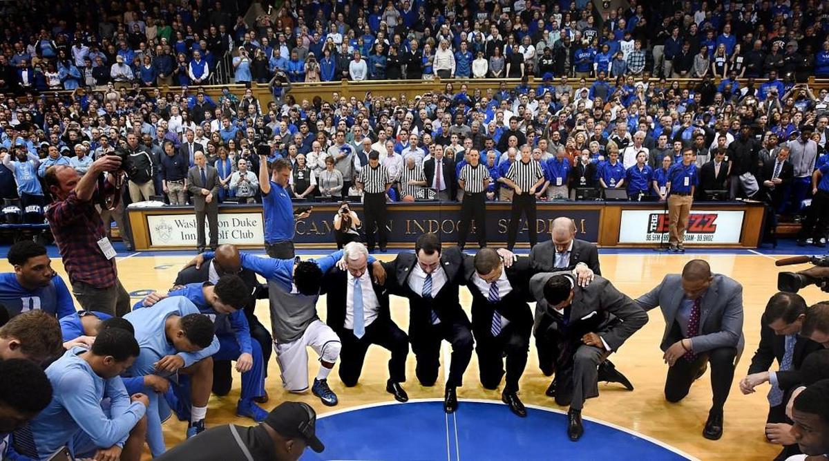 Duke and North Carolina players and coaches meet at center court for a moment of silence to honor of legendary UNC coach Dean Smith prior to the start of their game on Feb. 18, 2017.