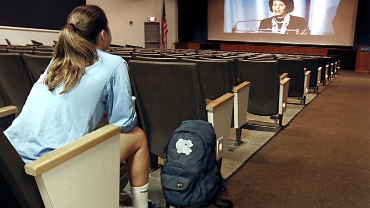 As UNC Chancellor Carol Folt, above right, made her opening remarks for the Wainstein Report press conference at the Kenan Center on the UNC campus on Oct. 22, 2104, UNC women’s soccer player Sarah Thompson, left, had the whole UNC Student Union auditorium to herself.