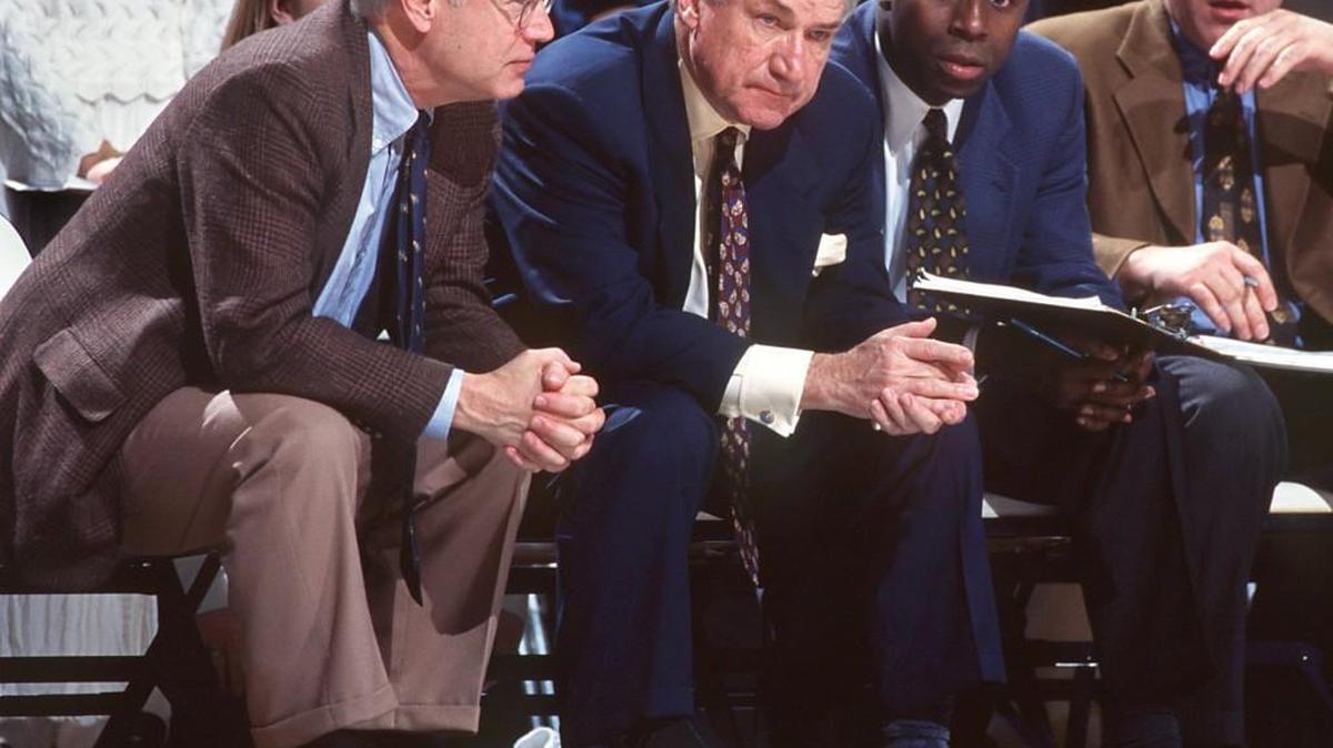 The UNC coaching staff watches during a game in 1997. From left: assistant coach Bill Guthridge, Dean Smith, assistant coach Phil Ford, and assistant coach Dave Hanners.