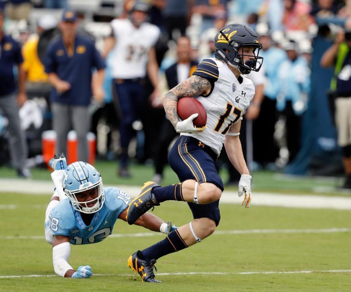 Cal's Vic Wharton III (17) evades UNC's Corey Bell Jr. (18) for a long TD pass play during the second quarter.