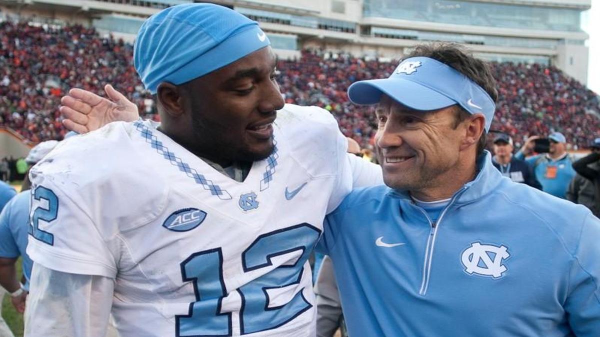 North Carolina coach Larry Fedora embraces quarterback Marquise Williams following the Tar Heels' 30-27 overtime win over Virginia Tech on Nov. 21 in Blacksburg, Va. It was longtime Virginia Tech coach Frank Beamer’s last home game.