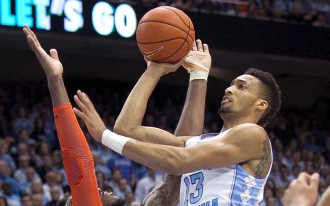 
UNC's J.P. Tokoto (13) puts up a shot over Syracuse's Rakeem Christmas (25) during their game on January 26, 2015, at the Smith Center in Chapel Hill, N.C.
