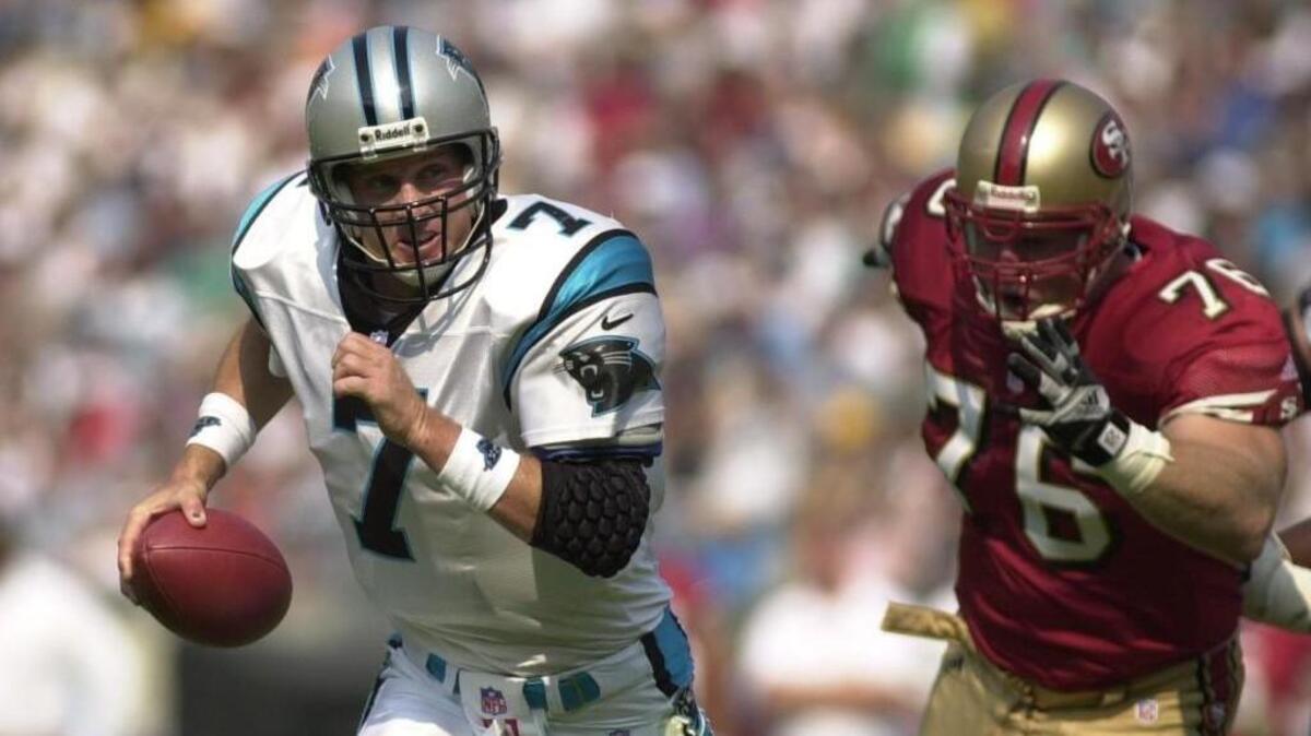 Panthers quarterback Steve Beuerlein, left, is chased by Nate Hobgood-Chittick in 2000.