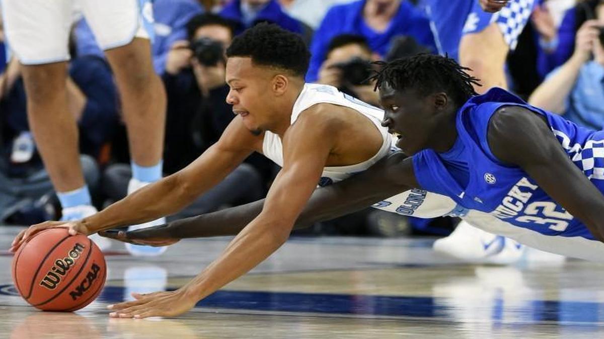 UNC’s Nate Britt and Kentucky’s Wenyen Gabriel dive after a loose ball during the CBS Sports Classic at T-Mobile Arena in Las Vegas.
