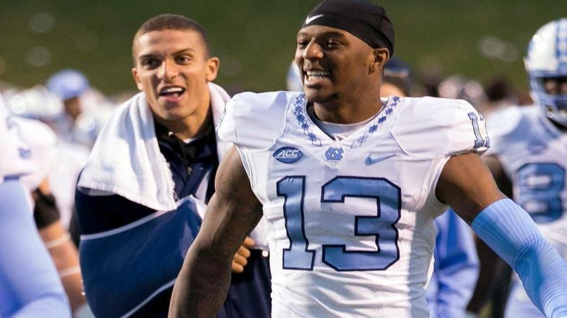 North Carolina receiver Bug Howard (13) leaves the field with teammate Mack Hollins, left, following the Tar Heels’ 35-14 victory over Virginia. Howard is wearing No. 13 to honor Hollins, who suffered a season ending injury last week.