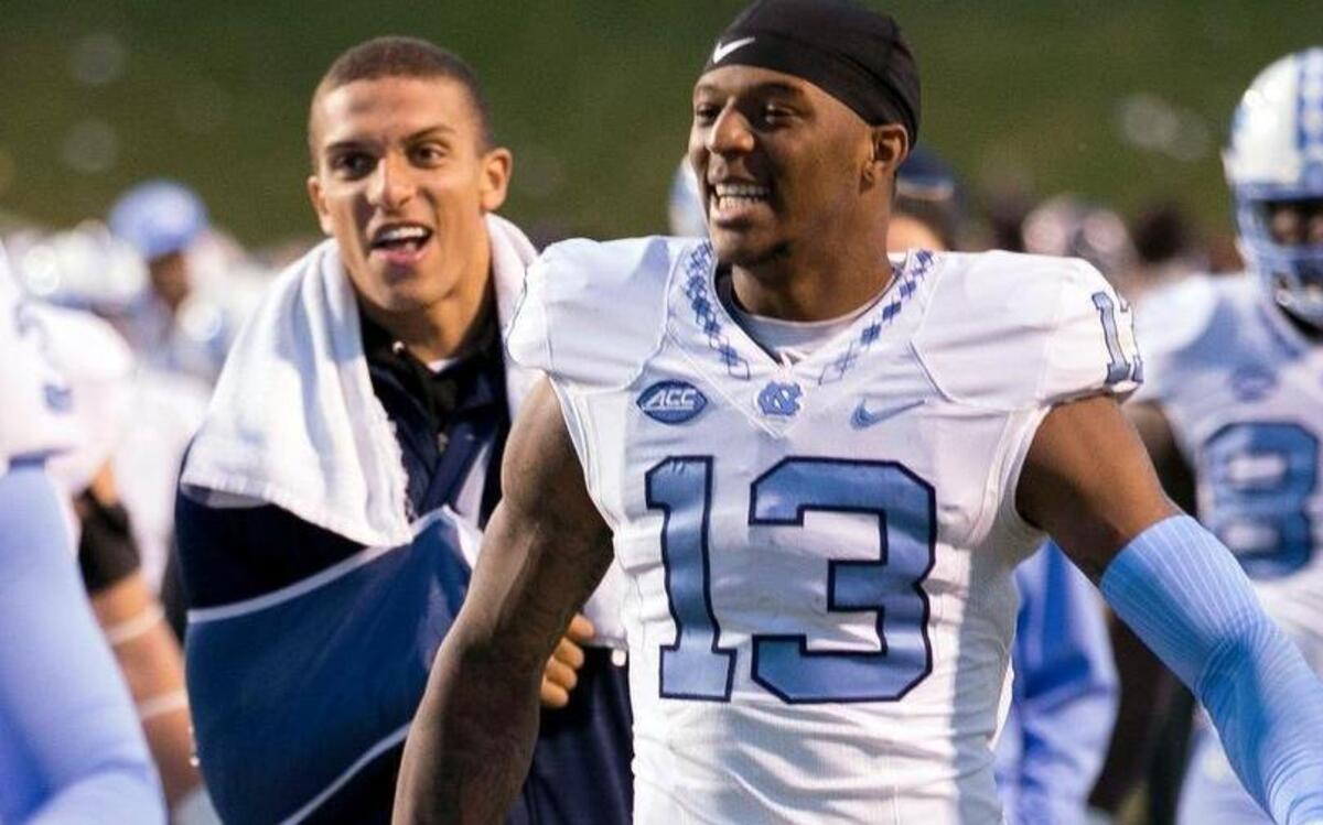 North Carolina receiver Bug Howard (13) leaves the field with teammate Mack Hollins, left, following the Tar Heels’ 35-14 victory over Virginia. Howard is wearing No. 13 to honor Hollins, who suffered a season ending injury last week.