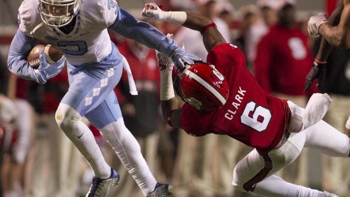 UNC’s Ryan Switzer, left, stiff arms N.C. State’s Niles Clark following a pass reception on Nov. 28. Switzer announced Wednesday that he’s returning to North Carolina for his senior season.