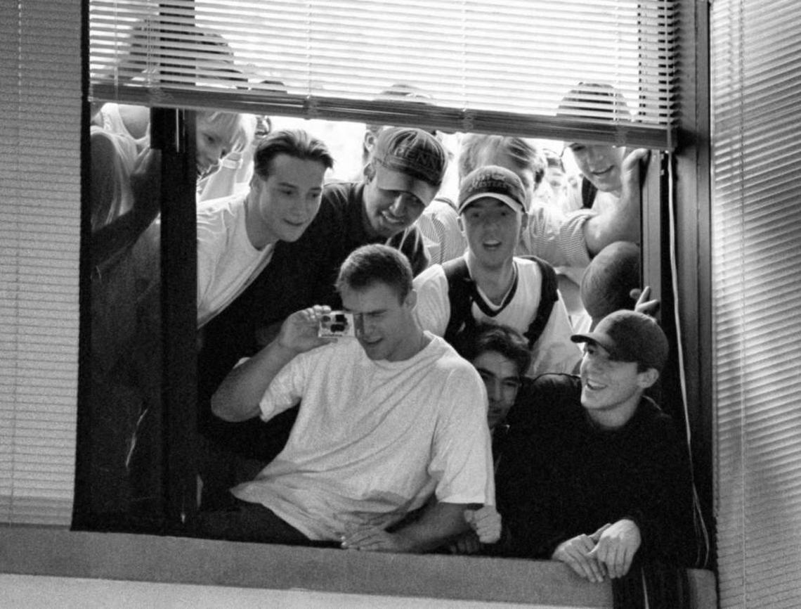 Students crowd a window overlooking the press conference in which UNC basketball coach Dean Smith announces his resignation. Students were not allowed into the building for the press conference.