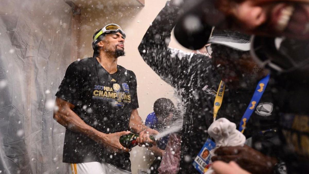 The Golden State Warriors' James Michael McAdoo celebrates in the locker room after defeating the Cleveland Cavaliers in Game 5 of the NBA Finals at Oracle Arena in Oakland, Calif., on Monday, June 12, 2017.