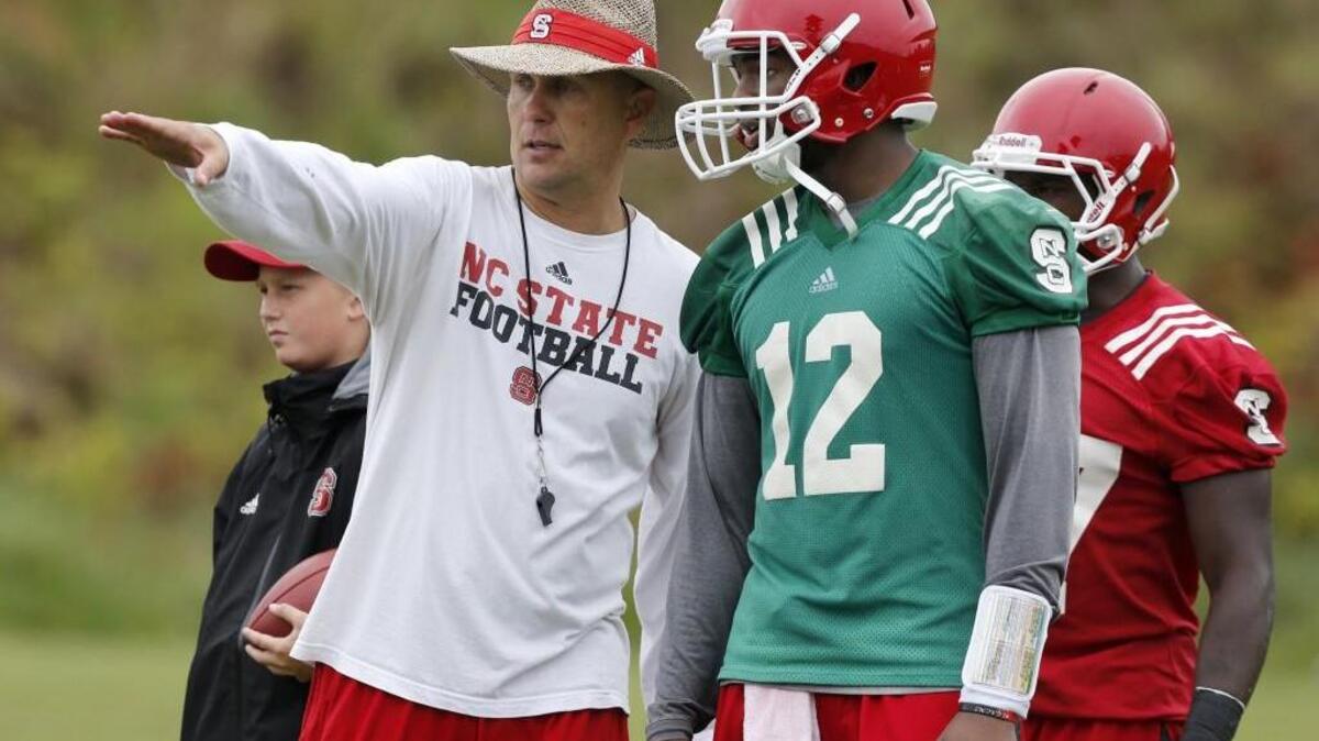 Former N.C. State offensive coordinator and quarterbacks coach Matt Canada, left, talks with quarterback Jacoby Brissett on Aug. 2, 2014. Canada, now with Pitt, will face UNC on Saturday in Chapel Hill.