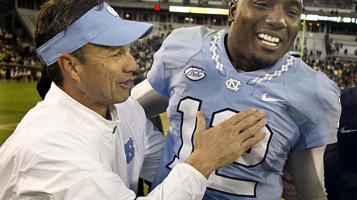 North Carolina head coach Larry Fedora embraces quarterback Marquise Williams (12) as they celebrates the Tar Heels' 38-31 victory against Georgia Tech in October. (Robert Willett/Raleigh News & Observer/TNS)