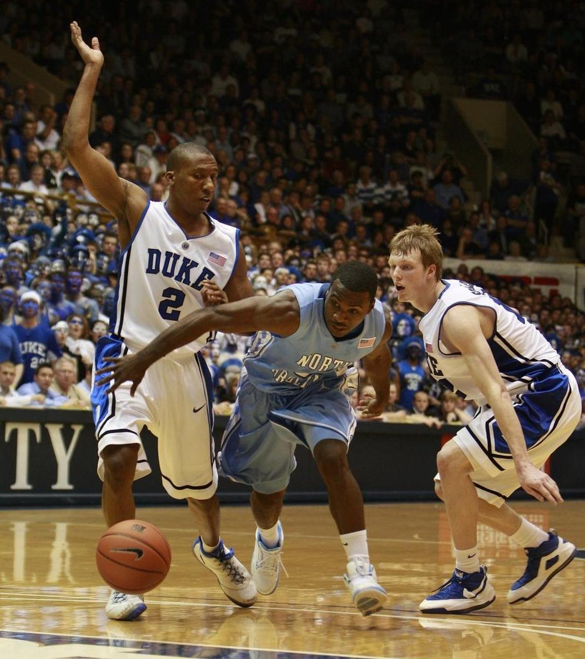 North Carolina guard Ty Lawson, middle, splits Duke defenders Nolan Smith, left, and Kyle Singler, right, in UNC’s 101-87 win over Duke on Feb. 11, 2009.