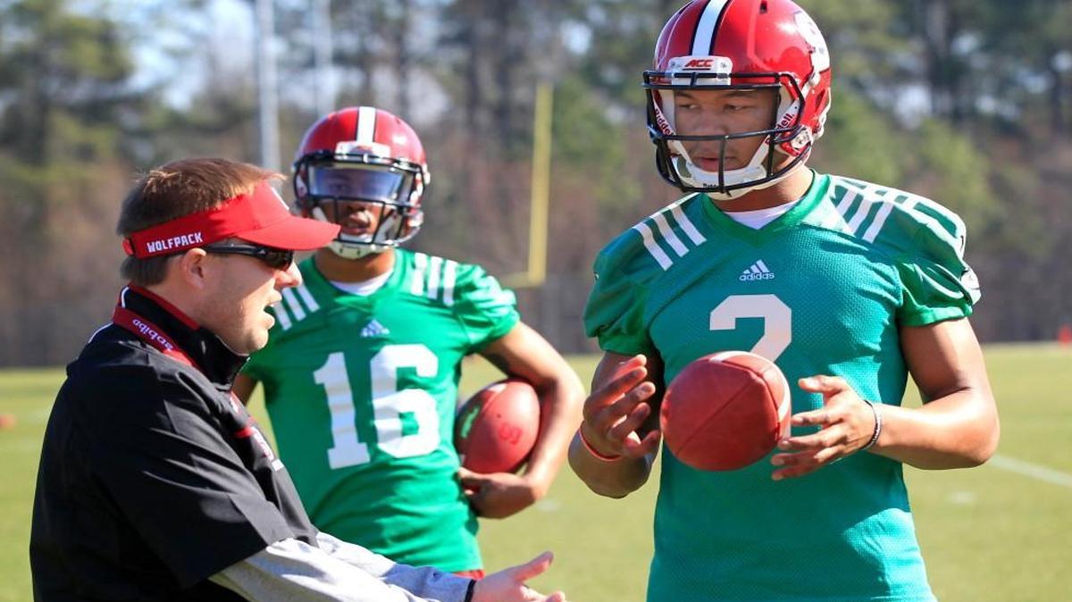 N.C. State offensive coordinator/quarterbacks coach Eli Drinkwitz, left, talks with quarterbacks Jalan McClendon (2) and Jakobi Meyers (16) during the first day of N.C. State football's spring practice in Raleigh Tuesday, March 1, 2016.