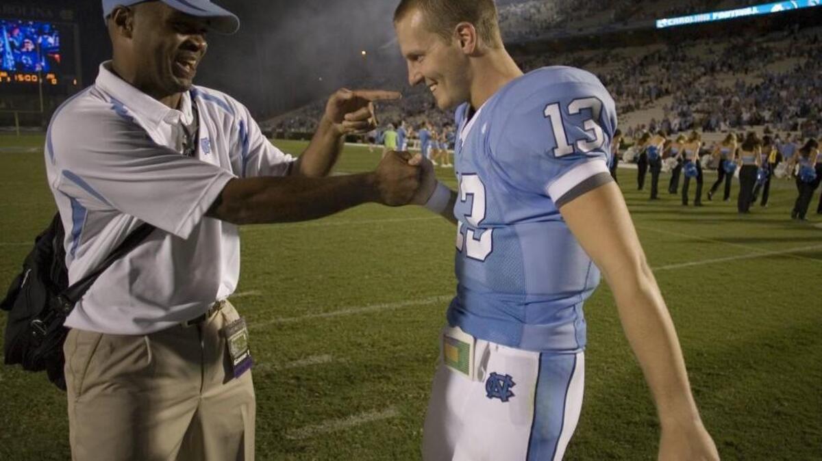 UNC quarterback T. J. Yates, right, is congratulated by assistant coach Tommy Thigpen in 2007. UNC announced on Tuesday that it has hired Thigpen as its linebackers coach.