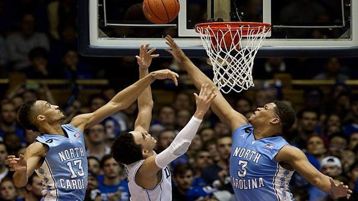 
Duke's Tyus Jones drives to the basket between North Carolina's Kennedy Meeks (3) and J.P. Tokoto (13) at Cameron Indoor Stadium in Durham, N.C., on Wednesday, Feb. 18, 2015. Duke won in overtime, 92-90.
