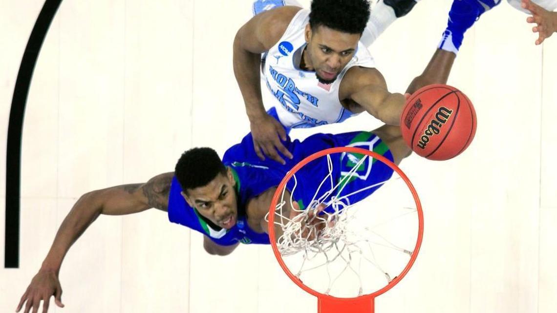 North Carolina’s Joel Berry II (2) taps in a basket over Florida Gulf Coast’s Julian DeBose (3) during UNC’s 83-67 victory in the first round of the NCAA Tournament on Thursday, March 17, 2016, at the PNC Arena in Raleigh.