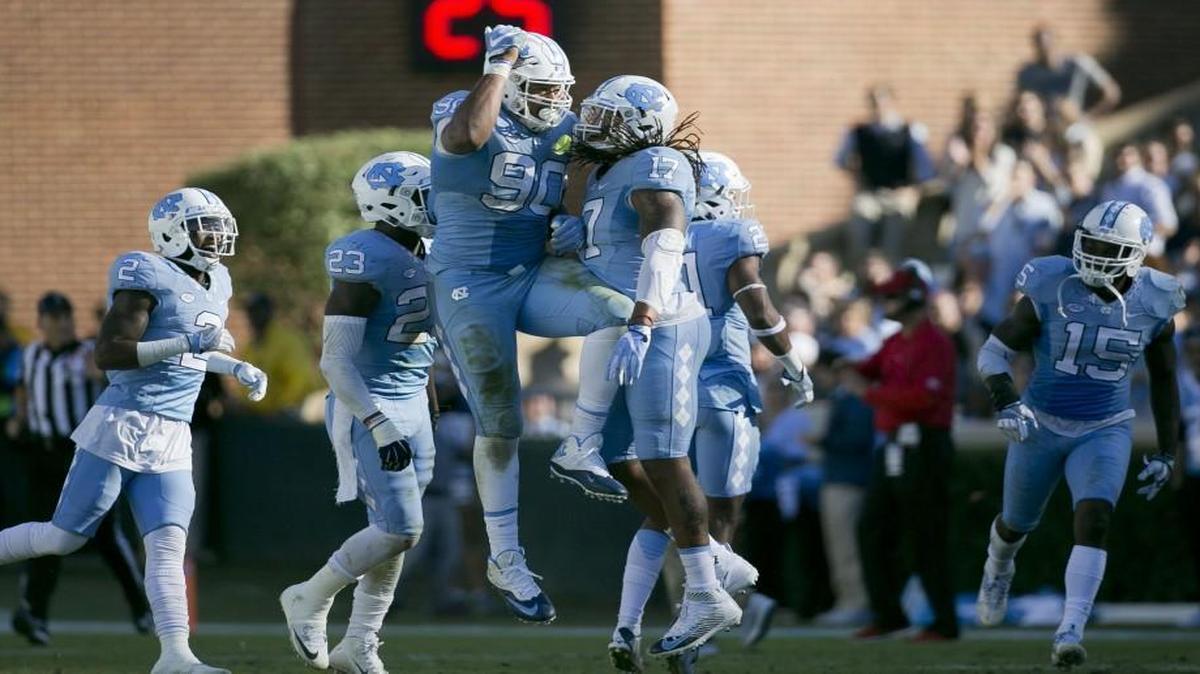 UNC’s Nazair Jones (90) and Dajaun Drennon (17) celebrate after the Tar Heels' defense stopped Georgia Tech on fourth down in the fourth quarter at Kenan Stadium.