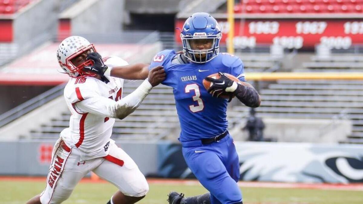 Wake Forest High’s Devon Lawrence, right, stiff arms Page defender Ronald Polite, left, in the NCHSAA 4AA football championship game in 2016. Wake Forest won the game 29-0.