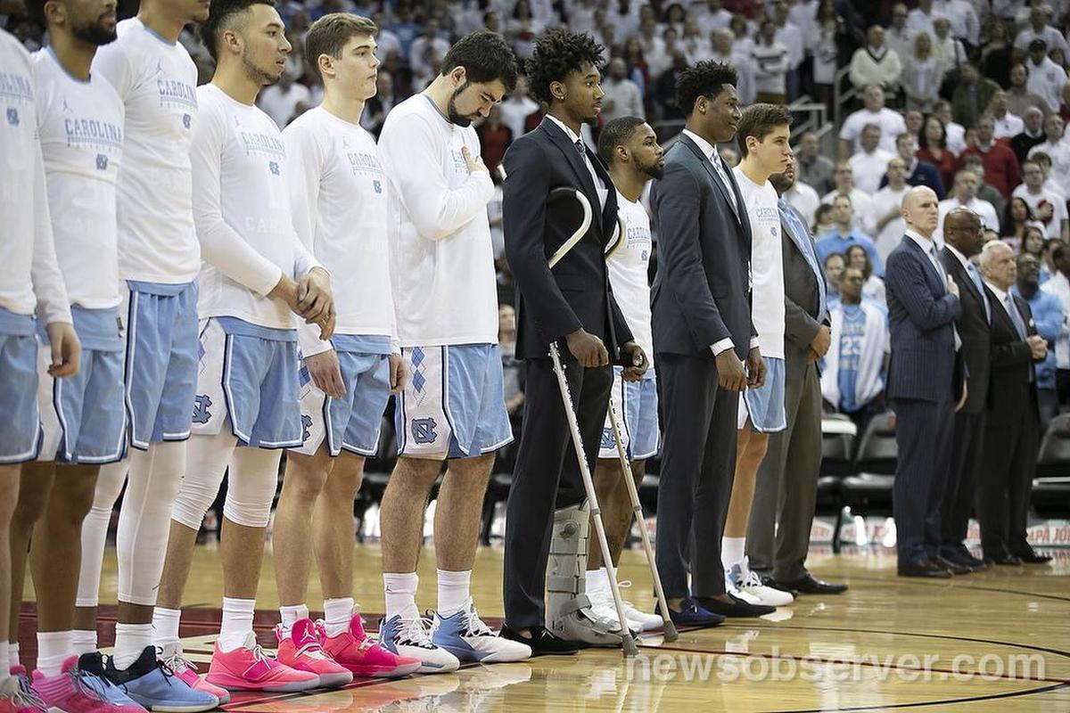 North Carolina’s Leaky Black, out with a sprained ankle, stands with his teammates for the National Anthem prior to their game against Louisville on Saturday, February 2, 2019 at the KFC Yum! Center in Louisville, Ky.